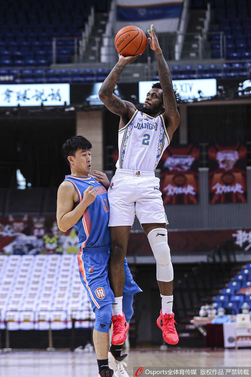 山西猛龙队球员张涵钧在浙江金牛球员的严密贴防下艰难控球，他侧身护球，额头青筋暴起，每一次运球都充满了力量的对决。