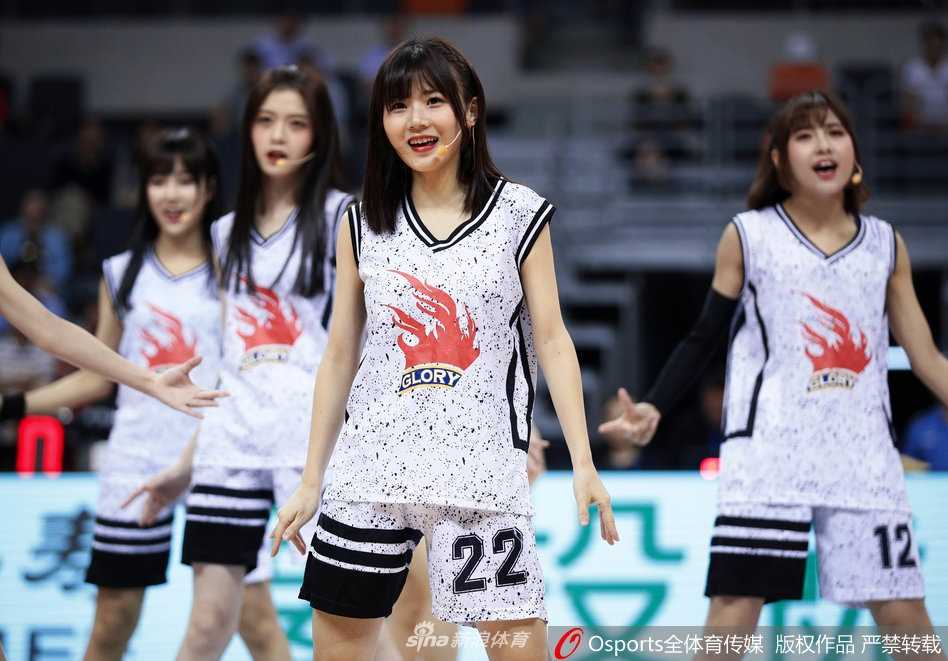 GNZ48多位成员在场地中央围成一圈，她们将手中的篮球高高抛起，脸上洋溢着自信而灿烂的笑容，展现了少女偶像的无限活力。