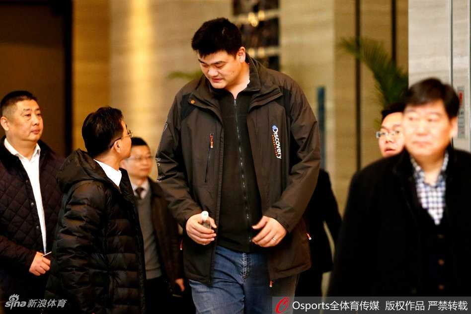 姚明在武汉体育学院篮球馆内驻足，专注地观看小球员们的训练对抗，眼神中流露出对篮球未来的殷切期望与关怀。
